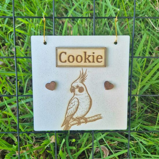 Plaque en bois personnalisable pour calopsitte, gravée avec prénom et motif, fabriquée en bois naturel issu de forêts durables.